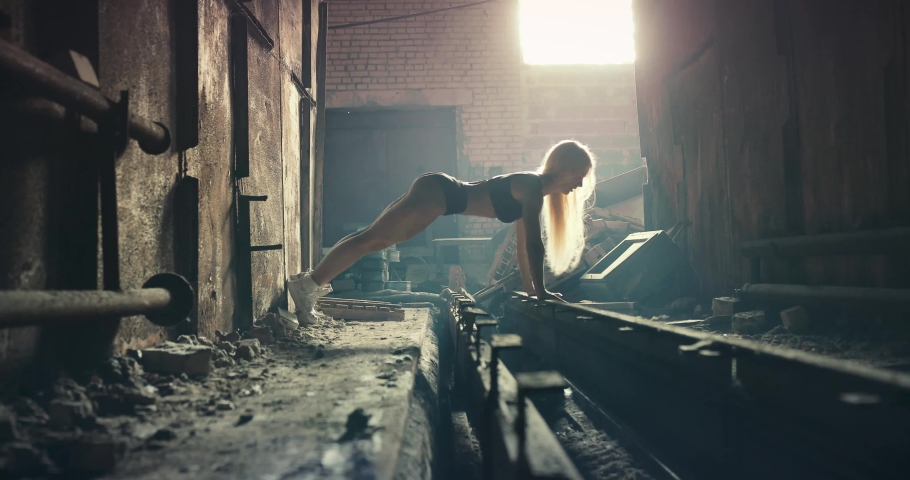 Side view of a fitness lady doing push-up excercise.