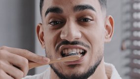 Extreme close up head shot bearded adult handsome Indian Spaniard Arab man brushing teeth in bathroom. Portrait hipster Arabic ethnicity guy doing oral mouth hygienic daily toothy procedure, toothcare - Powered by Shutterstock - Get 15% off with code: PIKWIZARD15