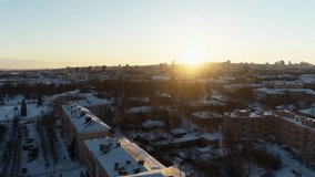 Bird's eye view on a sunny winter day. Scenic top view of the city, snow-covered and sunlit
