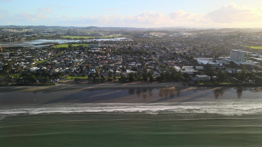 Tripod drone video of waves rolling in along the shoreline during golden hour