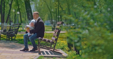 family walk in park, single father and little girl are sitting on bench in spring day, 4K, Prores