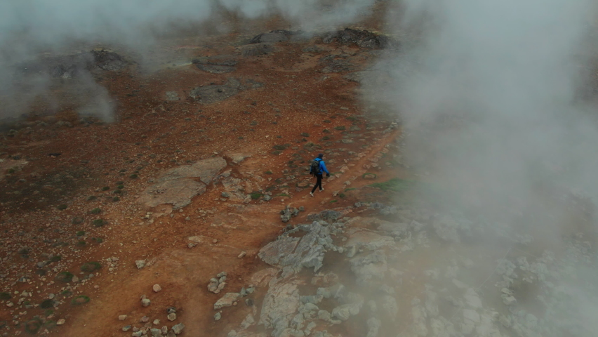 Aerial View of the Steaming Hverir Geothermal Area Near Lake Myvatn. Iceland. Panoramic Wide Shot. Man Tourist Walks Around. High Angle Shot. Drone is Over the Steam