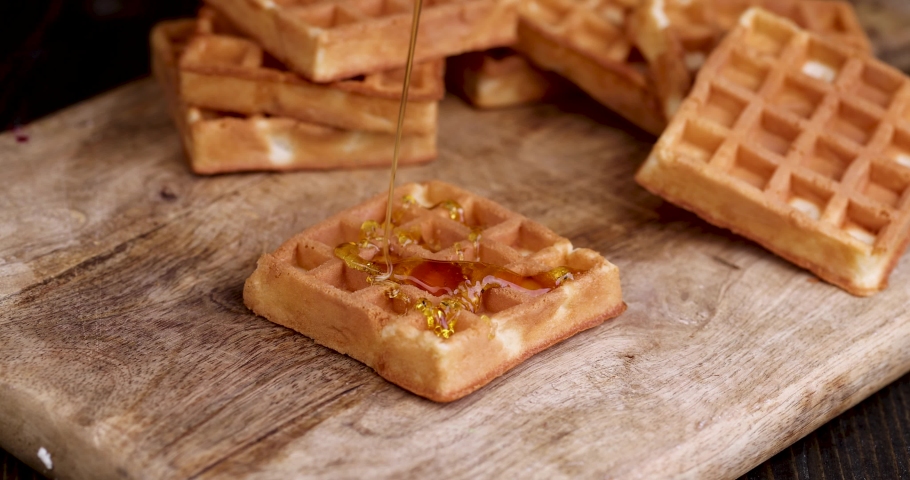 Watering soft waffles with bee honey during dessert cooking, making sweets from soft waffles and sweet bee honey | Shutterstock HD Video #1091114181