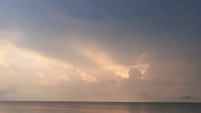 Dramatic thunder rain storm cloud n Pastel orange pink cloudscape on Sunset cyan blue sky over sea water n calm ocean wave in tropical summer sunlight n sun ray, 4k b-roll TimeLapse footage video 