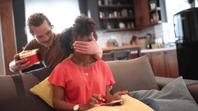 Young couple celebrating at home.Man giving gift to his girlfriend. - Powered by Shutterstock - Get 15% off with code: PIKWIZARD15