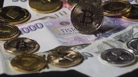 Bitcoin coin spinning between other cryptocurrencies on Czech money.