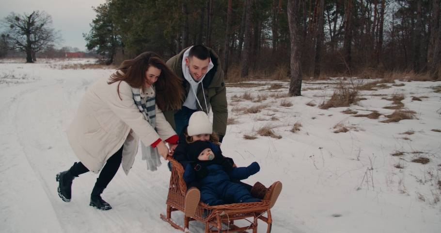 Happy full-fledged European Caucasian family walking having fun laughing on street outdoors in winter snow laughing running with sleds together. mom and dad with children hugging play slow motion 4k | Shutterstock HD Video #1091125469