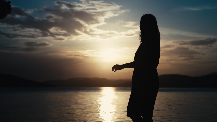 The guy makes a proposal to the girl to get married by the sea at sunset. Creating a new family and happy people together in a beautiful ocean landscape.