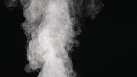 Water vapor. White jet of steam ascending and floats in air on black background. Micro drops of hot water are sprayed in air close up. Clouds of thick mist swirl. Smoke fog. Gaseous state.