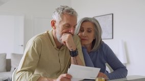 Older mature couple checking bank documents using laptop at home. Senior mid age retired man and woman reading paper bills, calculating pension or taxes, planning retirement finances, doing paperwork. - Powered by Shutterstock - Get 15% off with code: PIKWIZARD15