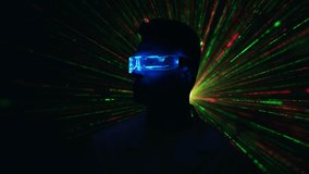 The attractive man in a futuristic glasses on a laser rays background