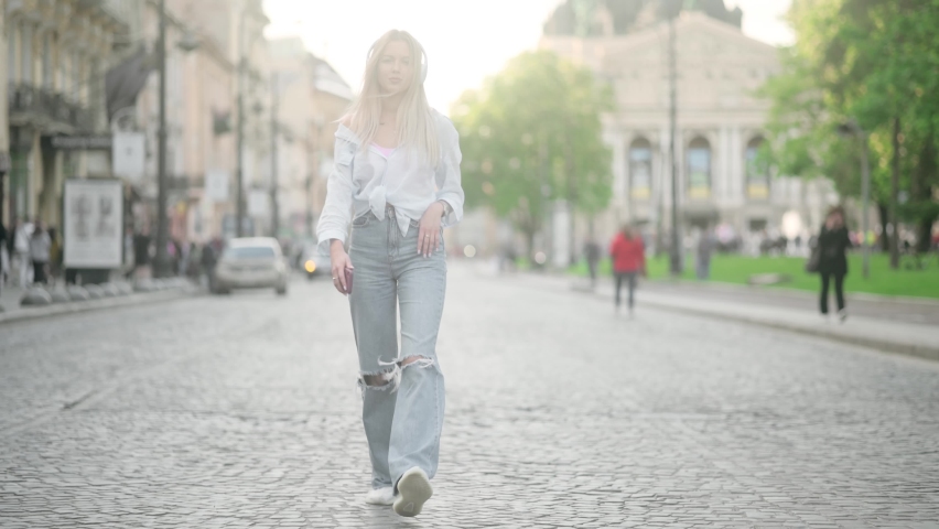 Portrait of attractive european girl with long blond hair walking in in old town of Lviv