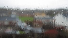Rain Drops On Window Glass In Monsoon Season. Water Drips Flow Down Blurry Nature Background, Static Shot. Outside Weather Is Bad. Autumn Or Spring Rainy Day Downpours. Depression, Melancholy Concept