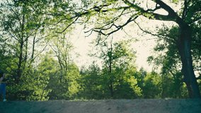 Girl on a morning jog in the park. slow motion video of a woman running on a path in the woods at sunrise in a natural landscape active sports lifestyle