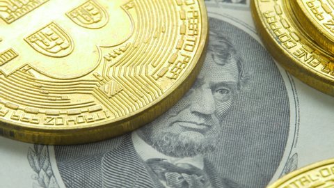 Abraham Lincoln looks on cryptocurrency BTC bitcoin coins. E-commerce or stock exchange. Digital cyberspace or payment system concept. Eye of 16th president of USA on Five Dollars bills