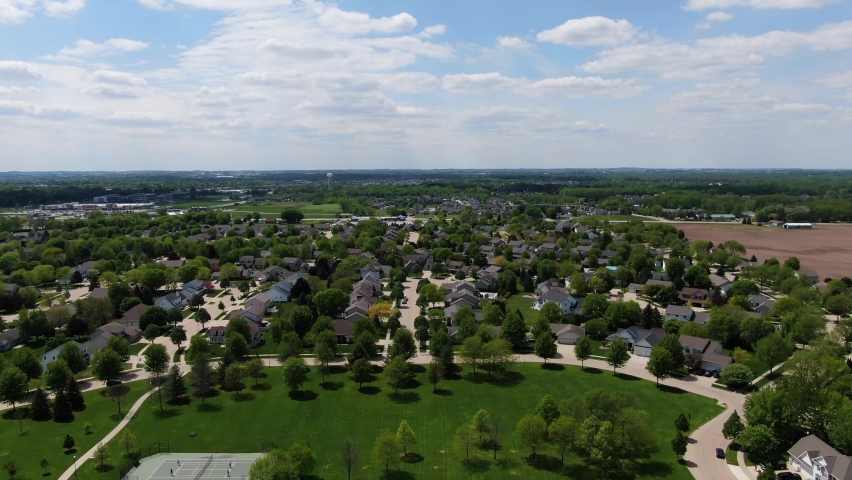 Wide aerial backwards pan of neighborhood in Wisconsin, USA on a cloudy day.