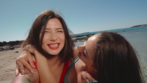 Two girl friends make Selfie on vacation Tourist woman laughing and walking beach promenade summer holiday European travel adventure. pretty female friends in swimsuits. LGBT Bikini girls slow motion.