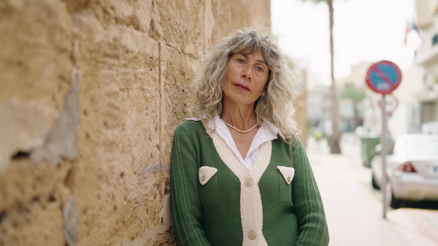 Middle age woman smiling confident standing at street