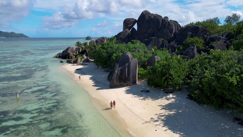 Anse Source d'Argent beach, La Digue Island, Seyshelles, Drone aerial view of La Digue Seychelles bird eye view.of tropical Island, couple men and woman walking at the beach during sunset at a luxury | Shutterstock HD Video #1091172763