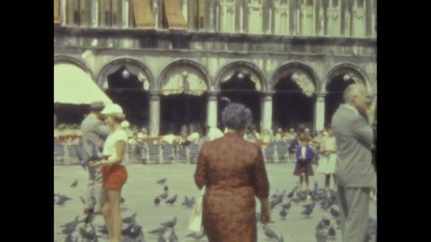 Venice, Italy may 1959: Tourists with pigeons in Venice in 50s
