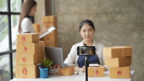 Asia SME owner or seller women micro influencer record live talk video camera at home studio. Asian woman influencer seller broadcast live streaming to sell product for online social marketing.