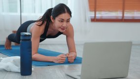 Asian woman in black sportswear workout exercise planking at home, exercise, fit, doing yoga, Sports and exercise to maintain good health, Fitness lifestyle and core exercises training.