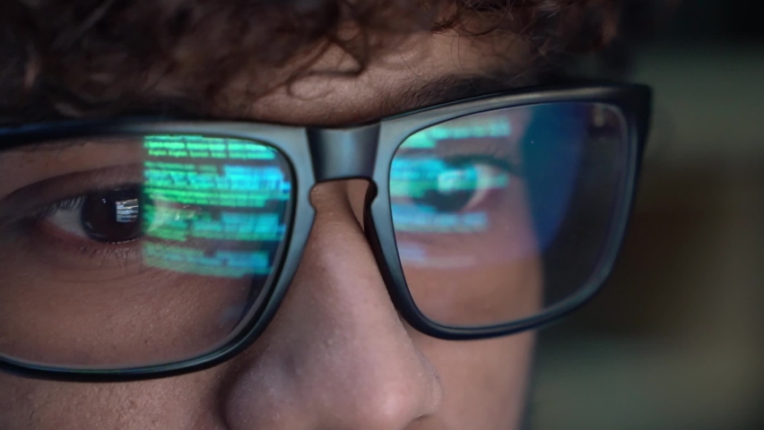Focused indian developer coder wears glasses working on computer looking at programming code data cyber security digital tech reflecting in spectacles developing software program, close up view. Royalty-Free Stock Footage #1091185331