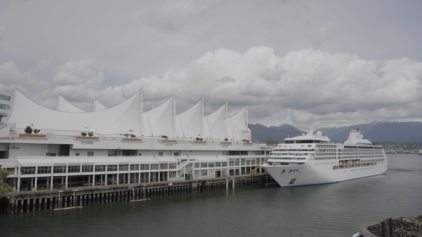 Luxury cruise docked near iconic Canada Place homeport, mountains in background, Vancouver bay, British Columbia, Canada