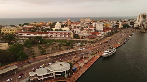 Cartagena, Colombia - May 08 2022: Aerial drone footage of the Cartagena de Indias colonial fortified old town by the Bodeguita marina with tour boat anchored  in Colombia, South America.