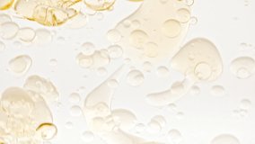 Slow Motion of Moving Yellow Golden Oil, Air Bubbles in Water Rising up on Light White Background. Transparent cosmetic gel fluid with bubbles. Macro Shot. - Powered by Shutterstock - Get 15% off with code: PIKWIZARD15