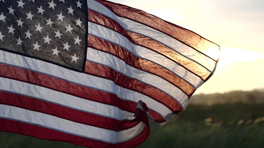 American USA flag waving in the wind against sunset in nature outdoor background. Concept of 4th of July, Memorial Day, Independence Day, Veterans Day, American Celebration, Patriots, Labor, President Royalty-Free Stock Footage #1091208241