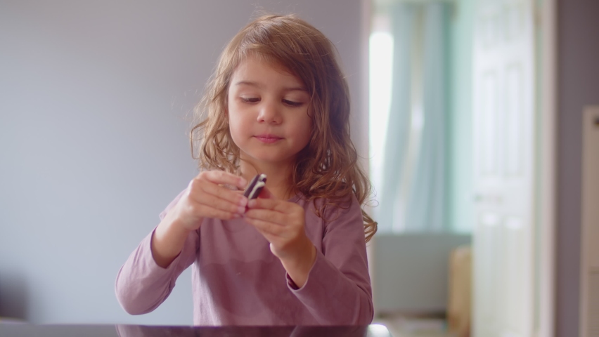 Portrait of a cute toddler girl eating a cookie. Shot in 4K on cinema camera.