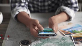 A young girl tourist explores travel destinations on her smartphone while looking at motivating photos. Girl traveler plans a trip on a smartphone while studying the area - Powered by Shutterstock - Get 15% off with code: PIKWIZARD15