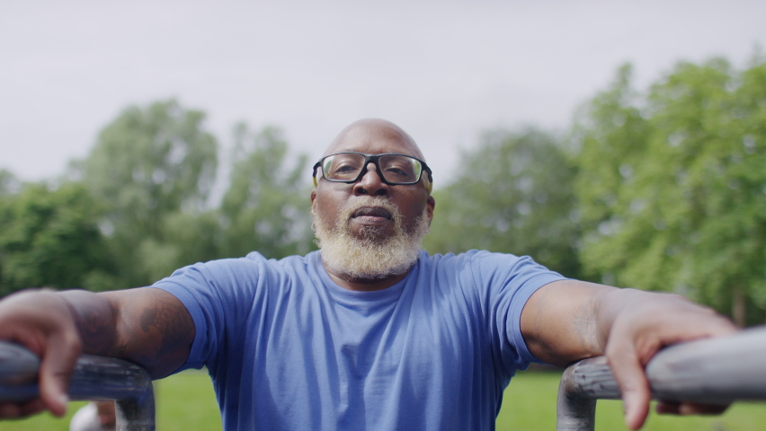 Active senior black male doing tricep dips on bars in an outdoor gym location | Shutterstock HD Video #1091222297