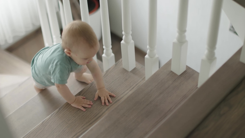 baby toddler boy climbing crawling upstairs home indoors learning to climb stairs. child kid using barefoot legs, tiny hands, going up wooden steps and stair. safety children concept Royalty-Free Stock Footage #1091227895