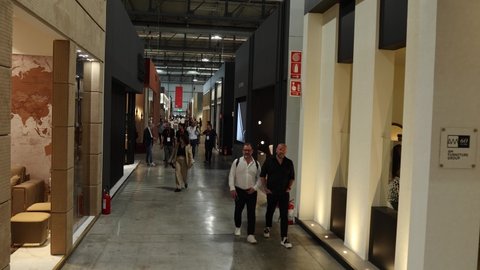 milan , Italy - 06 08 2022: salone del mobile walking corridor among designers booths, aerial-like shot, camera bottom up 4K 50 fps easy to slow motion