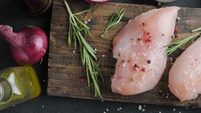 Fresh raw chicken breast fillets with rosemary, peppercorns and salt. Cooking healthy diet food. Top view. 4k video