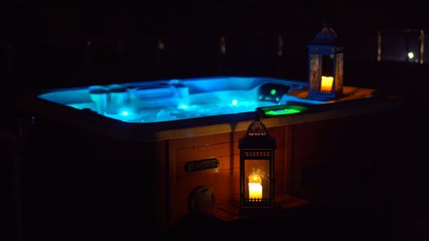 Night scene. A hot tub on a rooftop at night with candles on its side