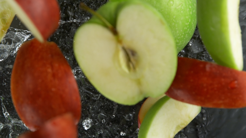 Super Slow Motion Shot of Red and Green Apple Cuts Falling and Splashing into Water at 1000fps. Royalty-Free Stock Footage #1091239437