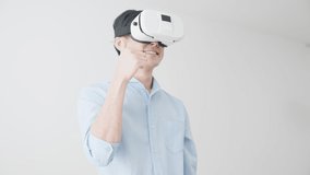 Young man indoors using VR device.