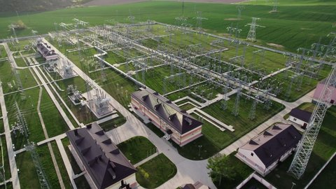 High voltage electrical substation. View from flying drone. Power plant with tall pylons and voltage distribution cables. Concept of energy, electricity industry, delivery and distribution of