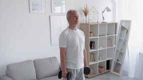 Home gym. Morning fitness. Active lifestyle. Health wellbeing. Happy athletic middle-aged man enjoying training arms muscles with dumbbells in light living room interior. - Powered by Shutterstock - Get 15% off with code: PIKWIZARD15