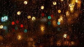 Falling rain drops on window surface. Night city and landscape with street lamps and a road. Raindrops flow down the glass on the window. Time lapse.4К. - Powered by Shutterstock - Get 15% off with code: PIKWIZARD15