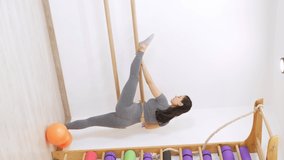 young woman is doing gymnastics in gym. Healthy lifestyle. vertical video wooden handrail