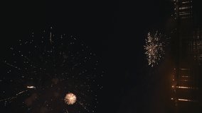 Vertical 4k footage of beautiful Fireworks on Deep Black Background Sky on Fireworks festival from sail yacht over night city lights in summer river night trip. High quality 4k raw video