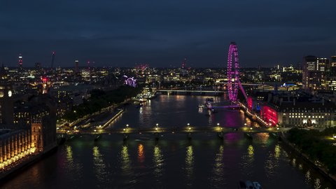 Stellar View and superb weather, Establishing Aerial View Shot of London UK, United Kingdom, at night evening,, Palace of Westminster, Parliament, slow flight over Thames River, push back from close