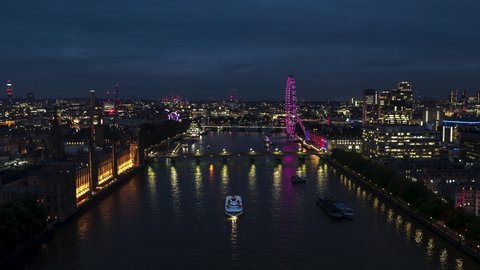 Stellar View and superb weather, Establishing Aerial View Shot of London UK, United Kingdom, at night evening,, Palace of Westminster, Parliament, slow flight over Thames River, push in from close