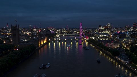 Stellar View and superb weather, Establishing Aerial View Shot of London UK, United Kingdom, at night evening,, Palace of Westminster, Parliament, slow flight over Thames River, push in from far