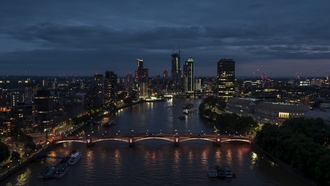 Establishing Aerial View Shot of London UK, United Kingdom, Battersea, Pimlico, Vauxhal, West Central London, push in over ther River Thames, small boat on the water, at night evening