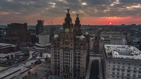 Liverpool, Great Britain - circa 2022 - Establishing Aerial View Shot of Liverpool UK, Merseyside, England United Kingdom, close view of Royal Liver Building, red sunrise